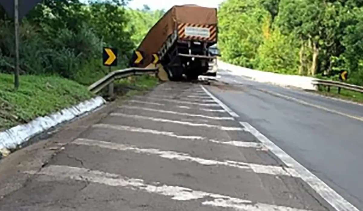 Carreta perde o freio, bate na traseira de caminhão e fica pendurada na ponte